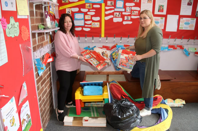 Emma Cavanagh, left, with Charley Atkinson, with some of the toys and games which were ruined by the flood.  AQ 6457
