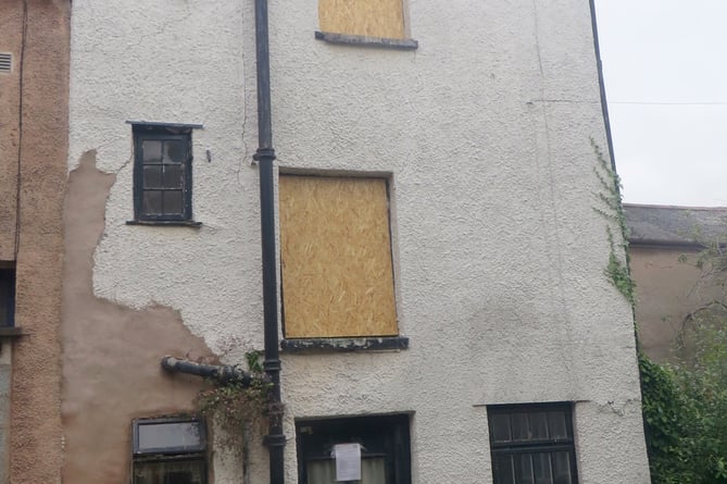 The Cott as it is now with boarded windows, the district council notice on the front door.  SR 2714
