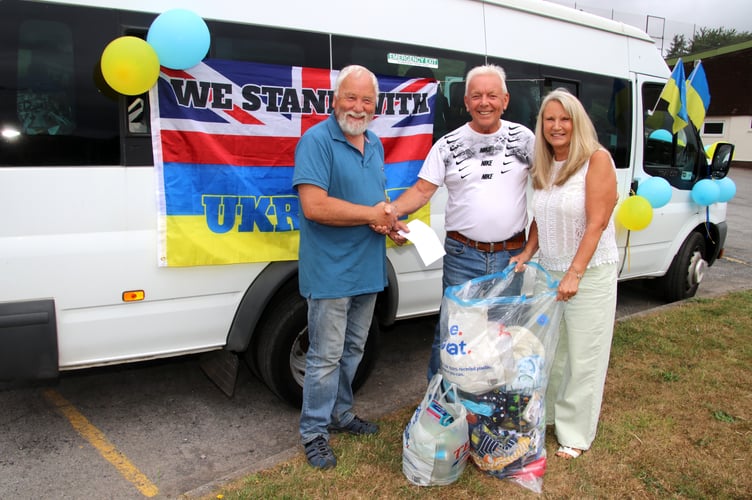 Joe, centre, receiving a cash donation towards his next trip with aid for refugees from Ukraine.  AQ 7746