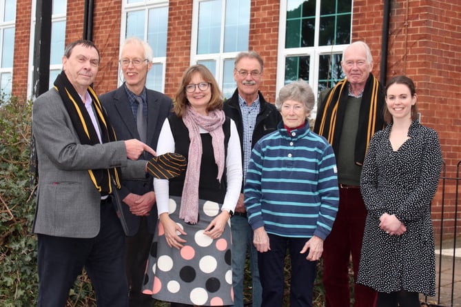 At a get-together to plan the reunion, left to right, Robert Orchard wearing his school scarf and pointing to his school hat, John Quicke, Acting Head Alexandra Blagden, Brian Harding, Marion and Paul Evans, Paul wearing his school scarf and Clare Marcus-Embleton, Business Manager and the group’s QE contact. SR 7033
