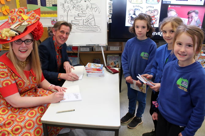 Sarah McIntyre and Philip Reeve signing books for pupils at Yeoford.  SR 7213