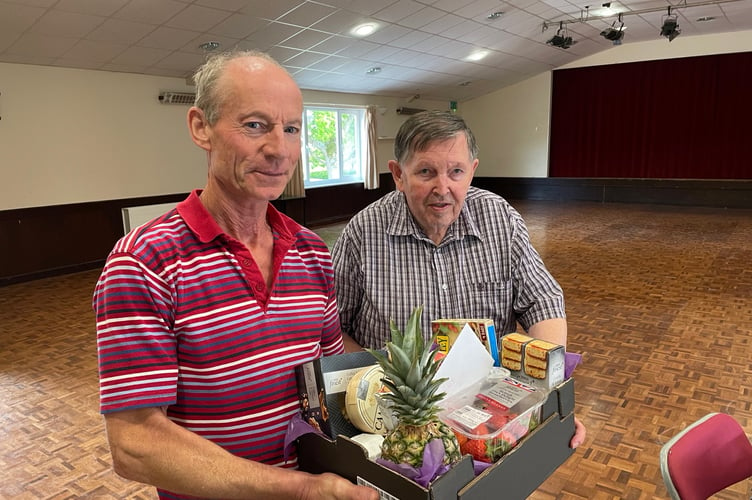 Mike Snow, left, presenting a hamper to Tony Wright after he steps down after 35 years as treasurer of Sandford Parish Hall.