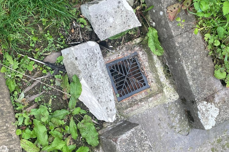 Two pieces of the broken gravestone after being moved from the path.  AQ 2738