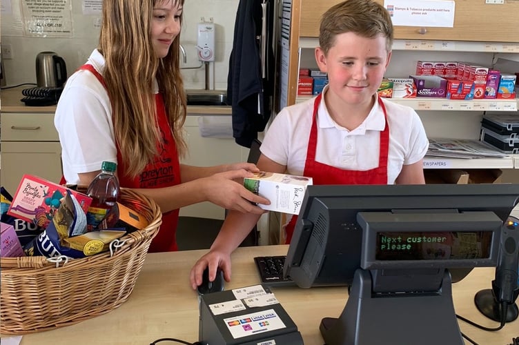 Spreyton Primary School Year 6 students Suzan Dack and Jack Short managing the Thursday morning rush hour with ease, at Spreyton Village Community Shop.