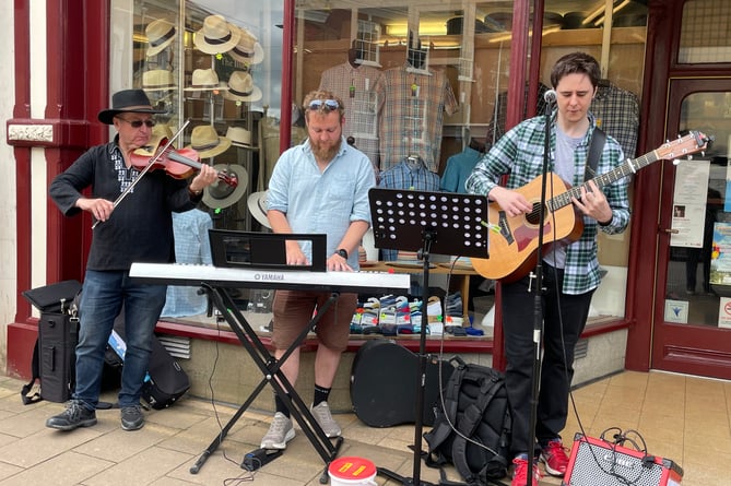 Buskers outside A E Lee (Outfitters) Ltd as part of Busk It!  AQ 5577
