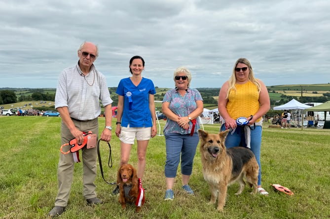 The Champion dog was purebred working cocker spaniel Otto owned by Marie Reynolds of Coldridge, exhibited by Mr Reynolds, with second, Golden Shepherd ‘Cyan’ owned by Michelle Gillies of North Tawton.  Judge was Sara Thurgood of Lapford dog club, pictured with the dog show steward.  AQ 6477
