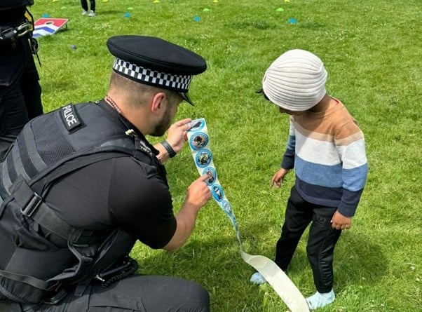 Sergeant James Wellard giving out stickers at the Nigerian community day.
