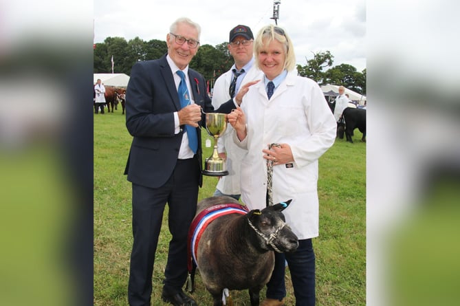 Vicky Smith of Thelbridge received the Supreme Champion Sheep award from Show President Ray Radford.  AQ 4837