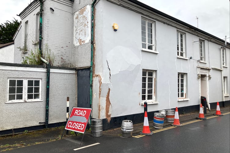 Traffic cones and beer kegs keeping pedestrians from using pavement