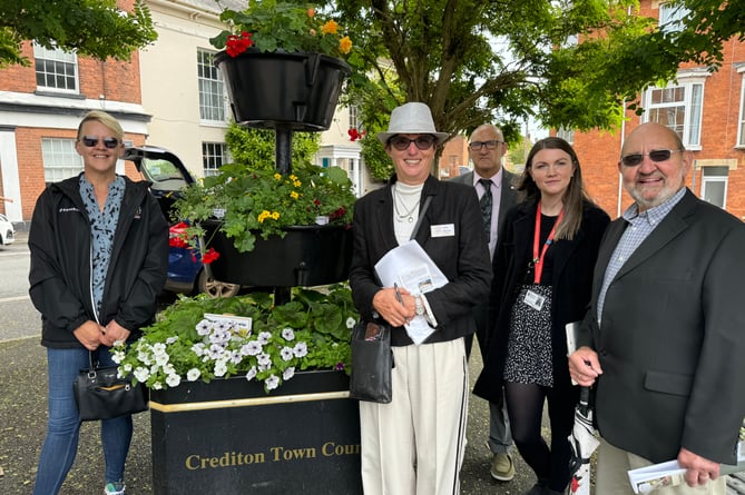 RHS Britain in Bloom judges admired the floral planters in Crediton Town Square during their visit to Crediton.  AQ 7682
