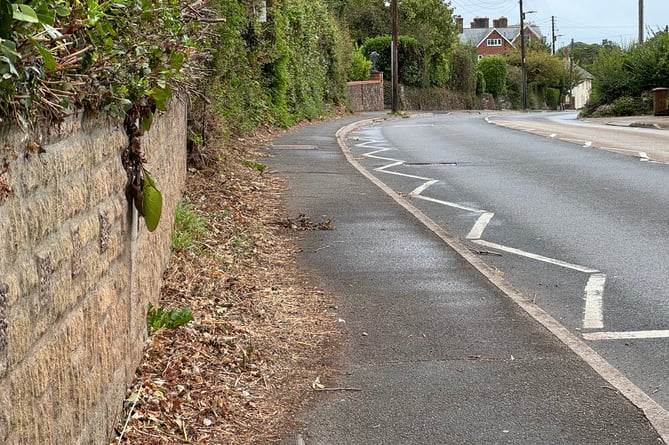 The debris left along the pavement which is making it dangerous for a wheelchair user accessing Crediton Hospital.  AQ 1277
