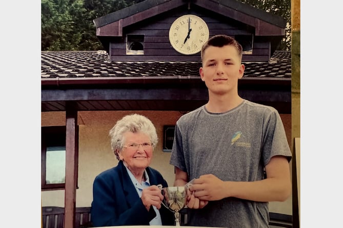 Margaret Phillips presenting the junior trophy to Ollie Knight.
