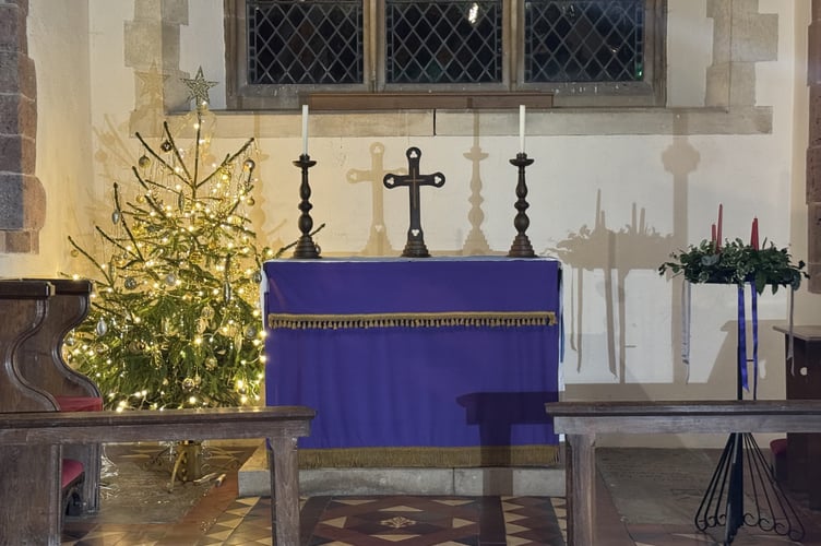 The lit Christmas tree beside the altar at Coldridge Parish Church