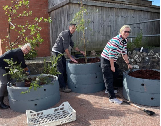 Members of Bow and District Garden Club help to plant up the new planters outside the village hall