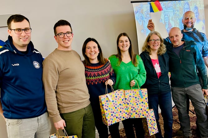 The winning team collect their prize of Romanian food from the quizmaster Tom.
