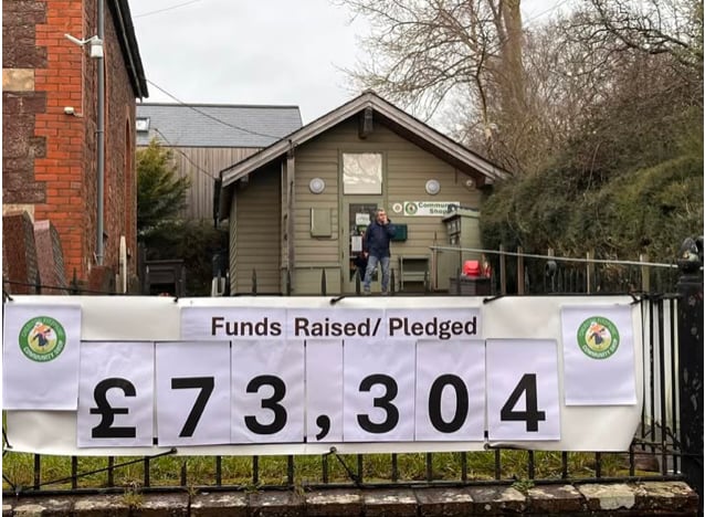 The sign outside Cheriton Fitzpaine Community Shop on the neighbouring chapel railings.
